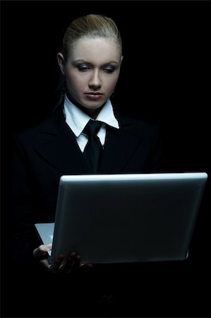 simsearch:400-03954172,k - Beautiful business woman wearing black tie and jacket isolated on black background with laptop computer Stock Photo - Budget Royalty-Free & Subscription, Code: 400-03964979