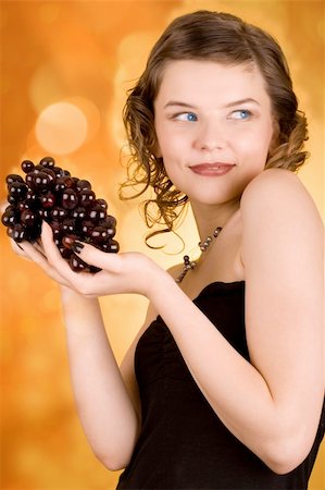 simsearch:400-03965656,k - glamorous girl holding some grapes in her hand Photographie de stock - Aubaine LD & Abonnement, Code: 400-03965650