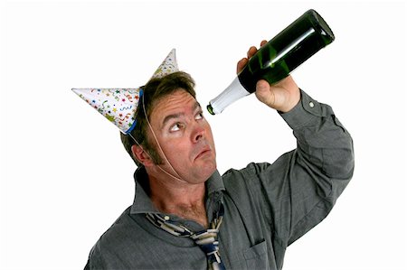 A man wearing two party hats and looking sadly up inside and empty bottle of champagne. Stock Photo - Budget Royalty-Free & Subscription, Code: 400-03967074