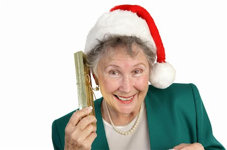 A pretty senior woman in a Santa Hat shaking a gift box to hear what is inside.  Isolated on white. Stock Photo - Budget Royalty-Free & Subscription, Code: 400-03967089