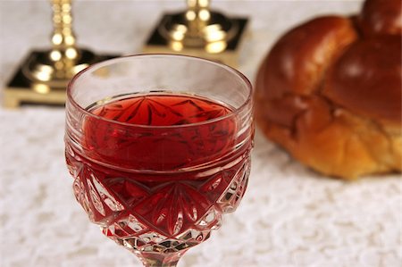 A glass of wine for Shabbat with candlesticks and challah in the background. Foto de stock - Super Valor sin royalties y Suscripción, Código: 400-03967083