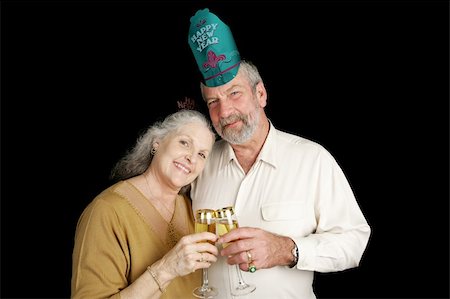 Good looking mature couple celebrating New Years Eve.  Isolated on black background. Stock Photo - Budget Royalty-Free & Subscription, Code: 400-03967394