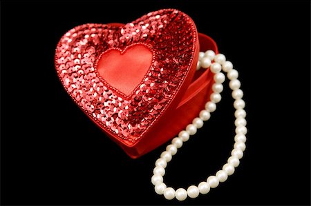 simsearch:693-06403301,k - A red satin heart shaped box filled with pearls, isolated on a black background. Stockbilder - Microstock & Abonnement, Bildnummer: 400-03967436