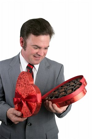 simsearch:400-04486211,k - A handsome well-dressed man looking down at a box of Valentines Chocolates and smiling.  Isolated on white. Stockbilder - Microstock & Abonnement, Bildnummer: 400-03967467