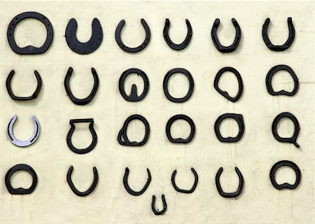 ferradura - Twenty five different types of old horseshoes lined up in rows against a pale cream  background. Foto de stock - Royalty-Free Super Valor e Assinatura, Número: 400-03968445