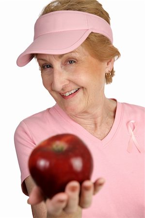 A woman dressed for breast cancer awareness holding out a delicious red apple for you.  Isolated on white. Stock Photo - Budget Royalty-Free & Subscription, Code: 400-03969218