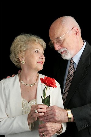 simsearch:400-03967470,k - A handsome senior couple in love.  He's giving her a rose.  A hearing aid is visible in her ear. Fotografie stock - Microstock e Abbonamento, Codice: 400-03969304