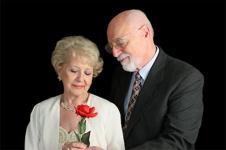 simsearch:400-03967470,k - A handsome senior couple (parents of the bride) dressed up for a special occasion.  He has given her a red rose. Fotografie stock - Microstock e Abbonamento, Codice: 400-03969324