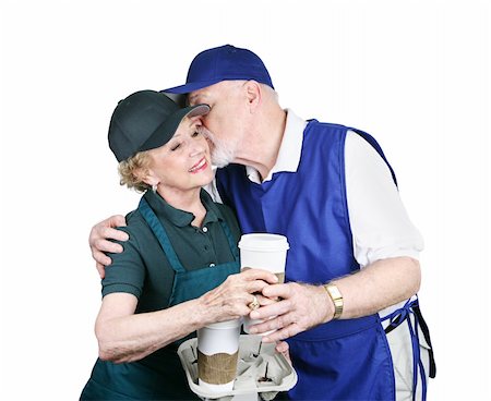 A senior couple working service jobs.  She's offering him coffee and he's kissing her.  Isolated on white. Stock Photo - Budget Royalty-Free & Subscription, Code: 400-03969397