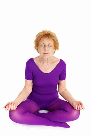 A fit seventy year old woman meditating during a yoga practice.  White background. Stock Photo - Budget Royalty-Free & Subscription, Code: 400-03969405