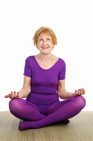A fit seventy year old woman in a modified lotus pose smiling in contentment.  White background. Stock Photo - Budget Royalty-Free & Subscription, Code: 400-03969401