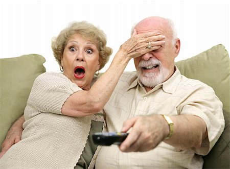 simsearch:400-05195435,k - A senior couple shocked by what they see on television.  She's covering his eyes and he's changing the channel.  White background. Stockbilder - Microstock & Abonnement, Bildnummer: 400-03969422