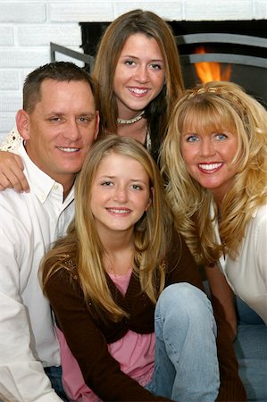 fireplace autumn - A beautiful family, father, mother and two daughters, smiling in front of their fireplace. Stock Photo - Budget Royalty-Free & Subscription, Code: 400-03969700