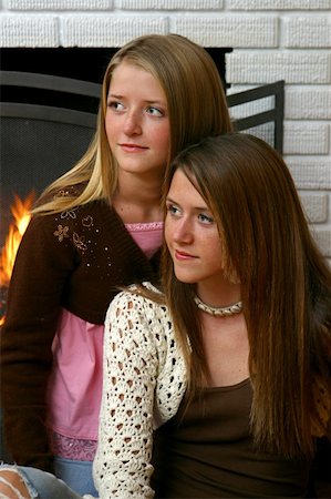fireplace autumn - Two beautiful teenaged sisters sitting beside the fireplace Stock Photo - Budget Royalty-Free & Subscription, Code: 400-03969776