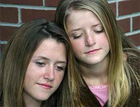 sibling sad - A closeup of two beautiful sisters looking down with sad expressions. Stock Photo - Budget Royalty-Free & Subscription, Code: 400-03969784