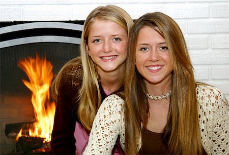 fireplace autumn - Two beautiful sisters at home in front of the fireplace. Stock Photo - Budget Royalty-Free & Subscription, Code: 400-03969788