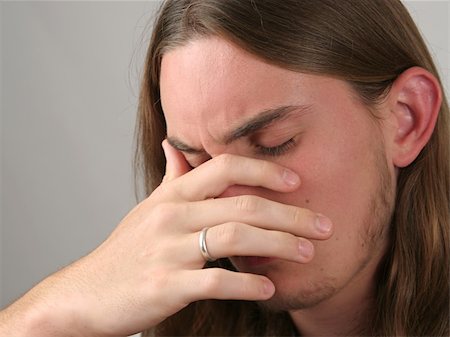 a teenaged boy with his head in his hands, very depressed or with a headache Stock Photo - Budget Royalty-Free & Subscription, Code: 400-03969794