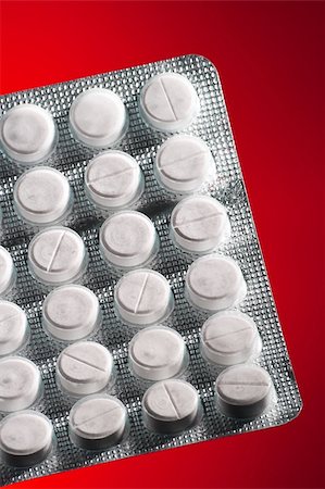 simsearch:649-08144833,k - White tablets in packing on an red background Fotografie stock - Microstock e Abbonamento, Codice: 400-03969959