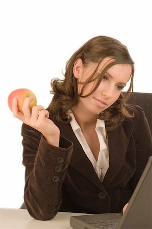 Young attractive woman looking at a laptop with an apple in her hand Photographie de stock - Aubaine LD & Abonnement, Code: 400-03960446