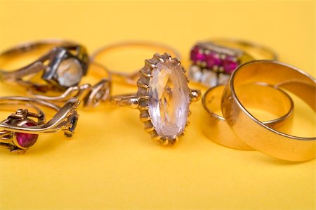 simsearch:400-04499320,k - Gold jewellery rings on yellow light bacground Fotografie stock - Microstock e Abbonamento, Codice: 400-03960459