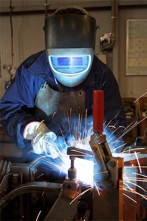 simsearch:649-05820711,k - Welder welding a metal part in an industrial environment, wearing standard protection equipment. Sparks flying, fumes, industrial background Photographie de stock - Aubaine LD & Abonnement, Code: 400-03961107