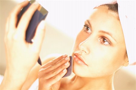 Pretty young brunette girl doing morning makeup. Girl has a towel on her head Stock Photo - Budget Royalty-Free & Subscription, Code: 400-03961532