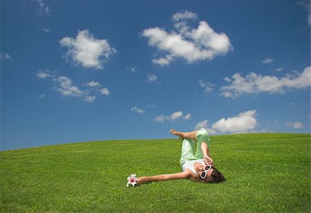 simsearch:400-04201795,k - Beautiful young woman laying down on a green meadow with a flower Fotografie stock - Microstock e Abbonamento, Codice: 400-03962885