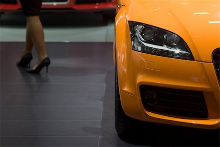 Orange luxury car and woman's leg in this composition where the focus is on the car Stock Photo - Budget Royalty-Free & Subscription, Code: 400-03974329