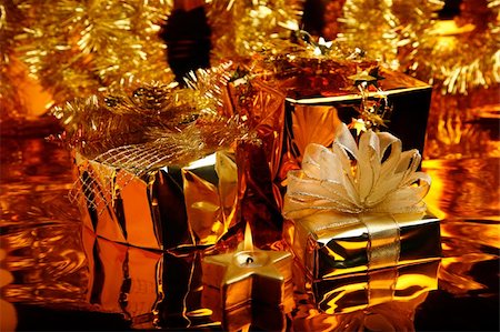 simsearch:400-06101480,k - Christmas gifts wrapped in gold paper on the shiny background of traditional decoration Stock Photo - Budget Royalty-Free & Subscription, Code: 400-03974568