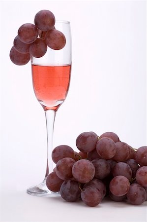 simsearch:400-04935153,k - A glass of rose wine with grapes against a plain background. Photographie de stock - Aubaine LD & Abonnement, Code: 400-03974819