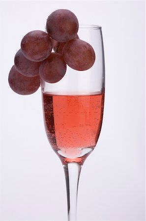 simsearch:400-04935153,k - A glass of rose wine with grapes against a plain background. Photographie de stock - Aubaine LD & Abonnement, Code: 400-03974820