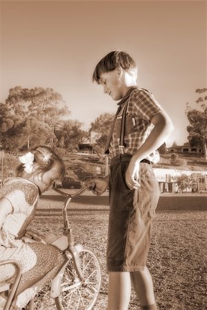 fashion kid with bicycle - diffused image of a young gentleman helping a little girl of the old tricycle Stock Photo - Budget Royalty-Free & Subscription, Code: 400-03975176