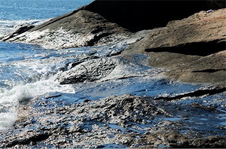 Years of oil residue glisten in the morning sun on wet rocks at Hazard Rock in Narragansett, RI Stockbilder - Microstock & Abonnement, Bildnummer: 400-03977644