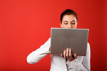 A young woman hiding behind and using a laptop computer wirelessly Stock Photo - Budget Royalty-Free & Subscription, Code: 400-03979096