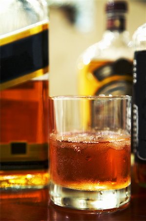 simsearch:400-05195371,k - Glass of whisky with an ice and bottles in a bar Stockbilder - Microstock & Abonnement, Bildnummer: 400-03979160