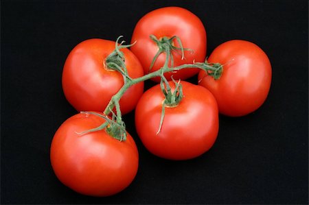 simsearch:700-00168950,k - A bunch of juicy red tomatoes on the vine against a black background. Photographie de stock - Aubaine LD & Abonnement, Code: 400-03970964