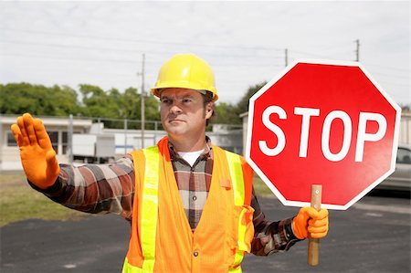 simsearch:614-06813293,k - A construction worker holding a stop sign and directing traffic. Foto de stock - Royalty-Free Super Valor e Assinatura, Número: 400-03971094