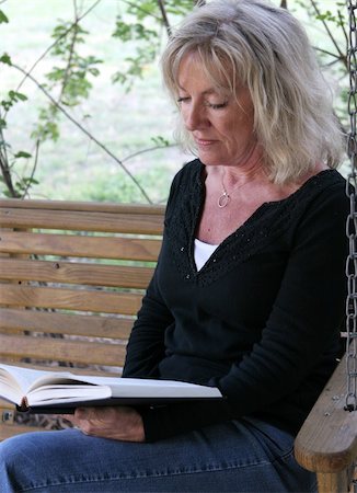 simsearch:400-03972220,k - A beautiful mature woman relaxing and reading on her porch swing. Fotografie stock - Microstock e Abbonamento, Codice: 400-03972236