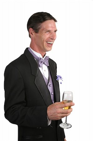 simsearch:652-03800461,k - A handsome man in a tuxedo, with a glass of champagne, laughing at an amusing story. Photographie de stock - Aubaine LD & Abonnement, Code: 400-03972351