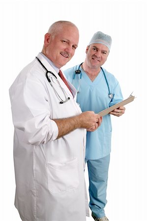 A vertical view of two friendly doctors reviewing a medical chart.  Isolated. (focus on doctor in white coat) Stock Photo - Budget Royalty-Free & Subscription, Code: 400-03972415
