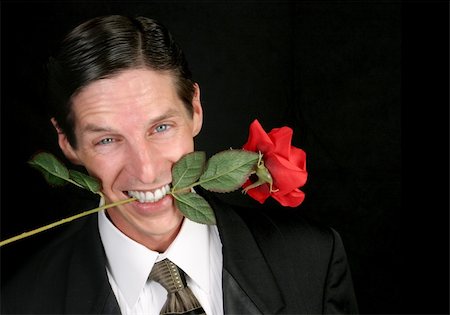 simsearch:400-04171391,k - A handsome man with a rose between his teeth - black background. Stock Photo - Budget Royalty-Free & Subscription, Code: 400-03972464