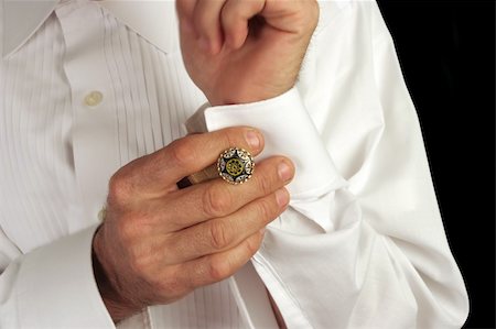 A man putting on antique cufflinks as he gets dressed in formal wear Photographie de stock - Aubaine LD & Abonnement, Code: 400-03972469