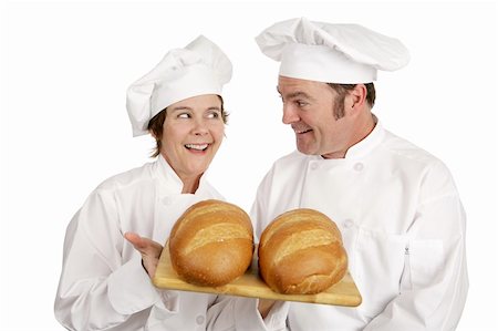 A male and female chef admiring two freshly baked loaves of bread.  Isolated on white. Stock Photo - Budget Royalty-Free & Subscription, Code: 400-03972779