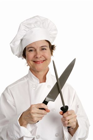 A pretty, smiling chef sharpening a kitchen knife.  Isolated on white. Stock Photo - Budget Royalty-Free & Subscription, Code: 400-03972835