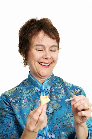 A pretty, mature woman dressed in a silk chinese blouse opening a fortune cookie and laughing at the fortune inside. Photographie de stock - Aubaine LD & Abonnement, Code: 400-03972833