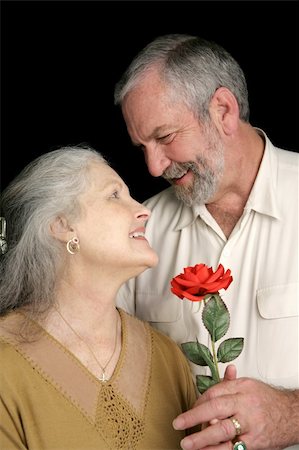 simsearch:400-03972903,k - A handsome mature husband surprising his wife with a red rose.  Vertical view over black. Stock Photo - Budget Royalty-Free & Subscription, Code: 400-03972902