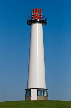 simsearch:400-04900592,k - A tall and gleaming white lighthouse at the harbors entrance Photographie de stock - Aubaine LD & Abonnement, Code: 400-03972978