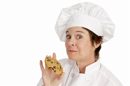 Chef enjoying a delicious fresh baked chocolate chip cookie.  Isolated on white. Stock Photo - Budget Royalty-Free & Subscription, Code: 400-03973136
