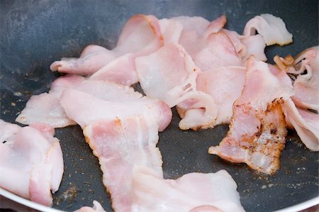 frying pan with bacon - Bacon being cooked in a frying pan Stock Photo - Budget Royalty-Free & Subscription, Code: 400-03984299