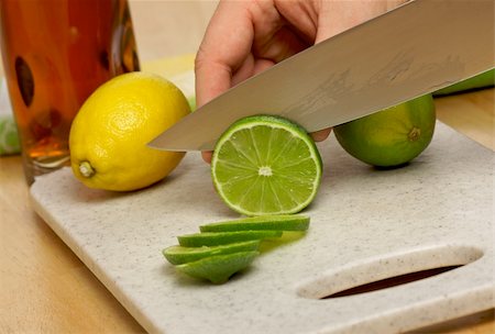 simsearch:400-04395073,k - Slicing a lime on a cutting board. Stock Photo - Budget Royalty-Free & Subscription, Code: 400-03985490